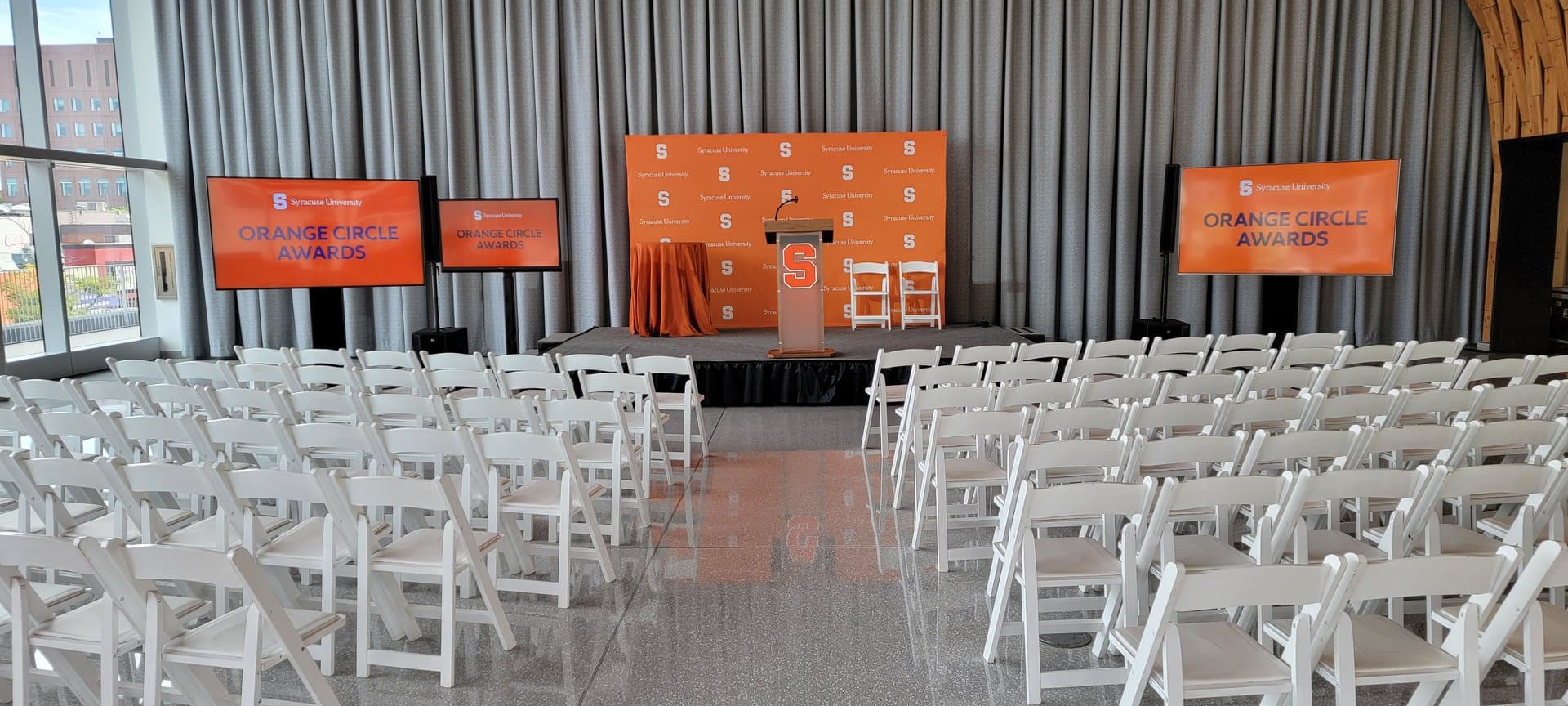 University awards stage with three presentation displays