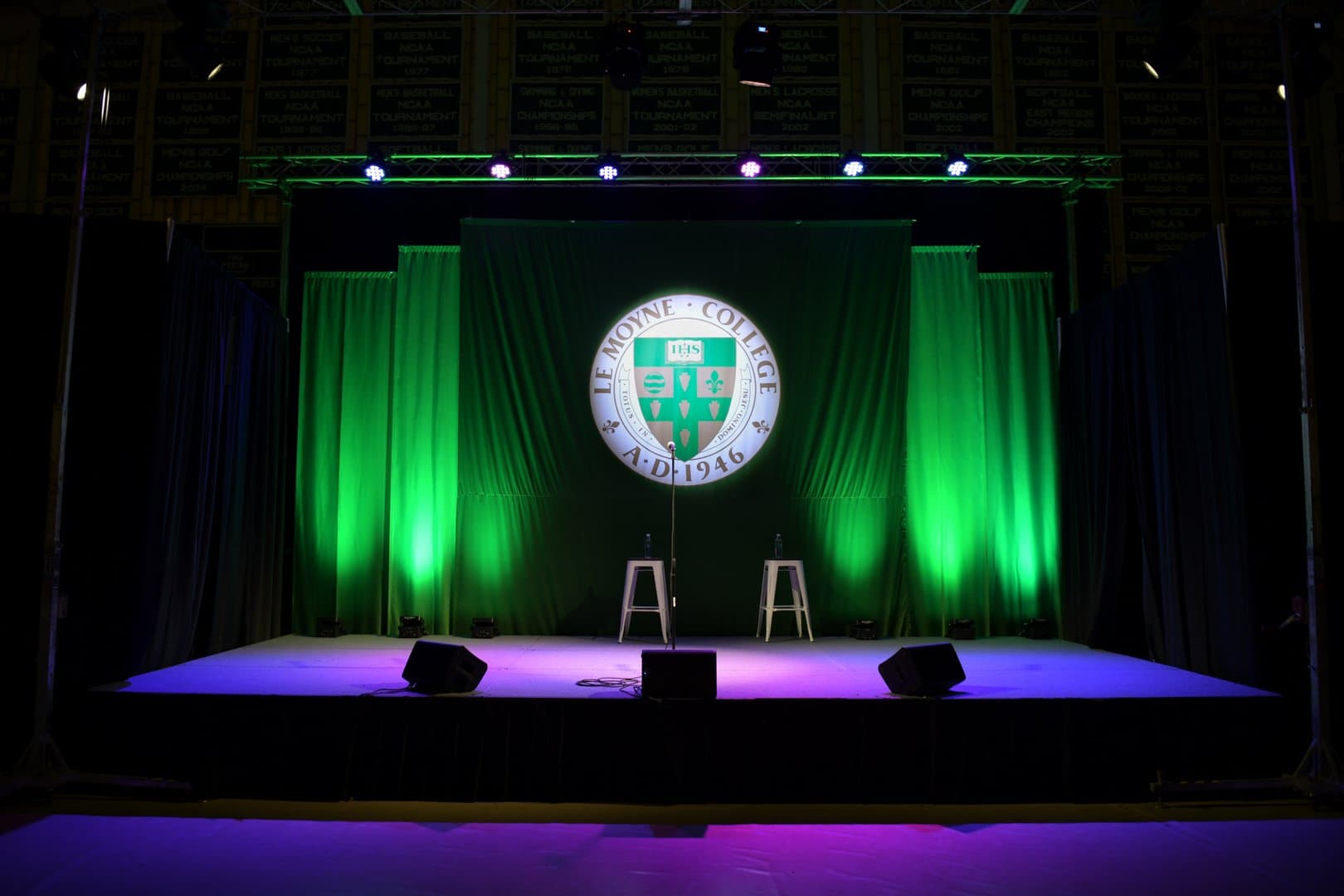 A university stage with branded projection, drape, and professional lighting